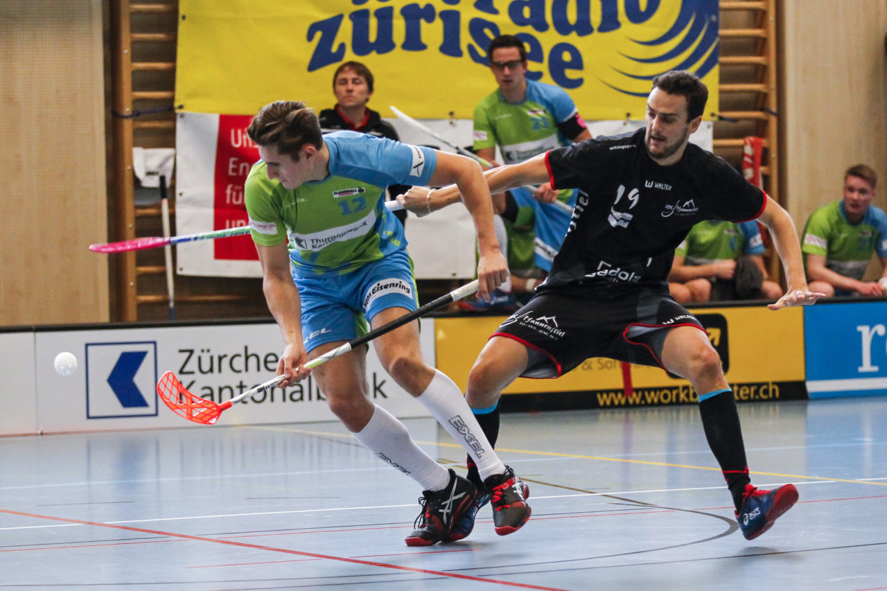 Simon Wachter (Nr. 12, Floorball Thurgau) im Zweikampf mit Marco Carigiet (Nr. 19, UHC Pfannenstiel Egg).

(8.10.2017; UHC Pfannenstiel Egg - Floorball Thurgau; Sporthalle Kirchwies, Egg)
Photos: www.unihockey-fotos.ch Claudio Thoma