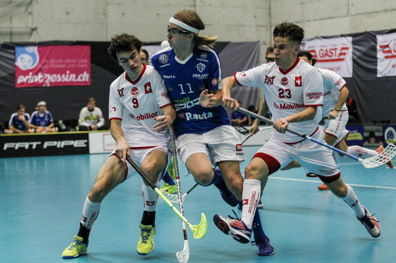 Noah Baschung (Nr. 9, Schweiz U19) und Gianluca Persici (Nr. 23, Schweiz U19) nehmen Niko Uurtio(Nr. 11, Finnland U19) in die Mangel.

4.11.2017; Schweden U19 - Tschechien U19, Sporthalle Grossmatt; Kirchberg)
Photos: www.unihockey-fotos.ch Claudio Thoma