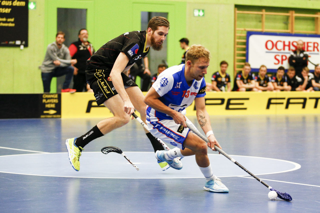 Kay Bier (Nr. 13, GC Unihockey) schirmt den Ball ab waehrend Mikko Hautaniemi (Nr. 5, HC Rychenberg Winterthur) der Stock bricht.

(Cup Halbfinale; GC - HC Rychenberg Winterthur; 12.1.2018,; Sporthalle Hardau, Zuerich)
Photos: www.unihockey-fotos.ch / Claudio Thoma