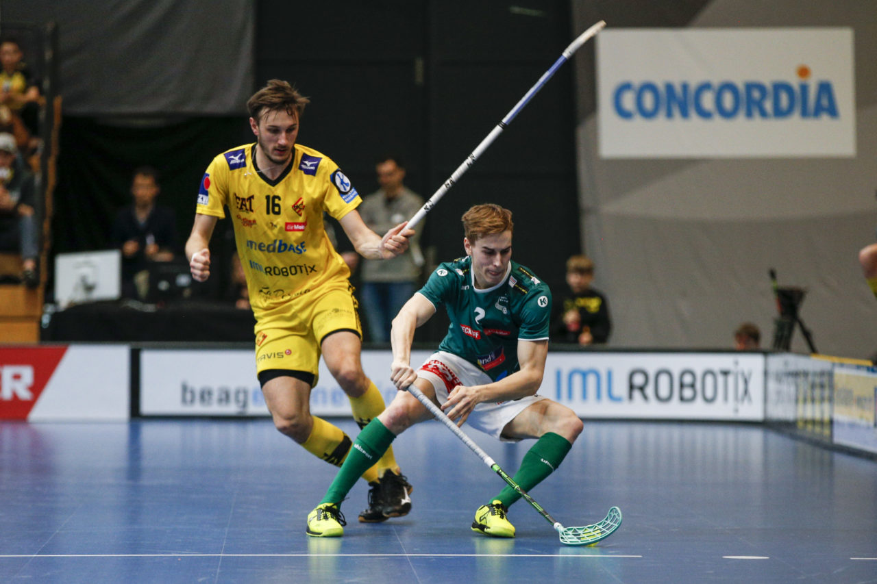 Nicola Bischofberger (Nr. 2, SV Wiler-Ersigen) schirmt den Ball vor Moritz Schaub (Nr. 16, HC Rychenberg Winterthur) ab.

(HC Rychenberg Winterthur - SV Wiler-Ersigen; Playoff Spiel 1; 17.3.2018; Eulachhallen; Winterthur)
Photos: www.unihockey-fotos.ch / Claudio Thoma