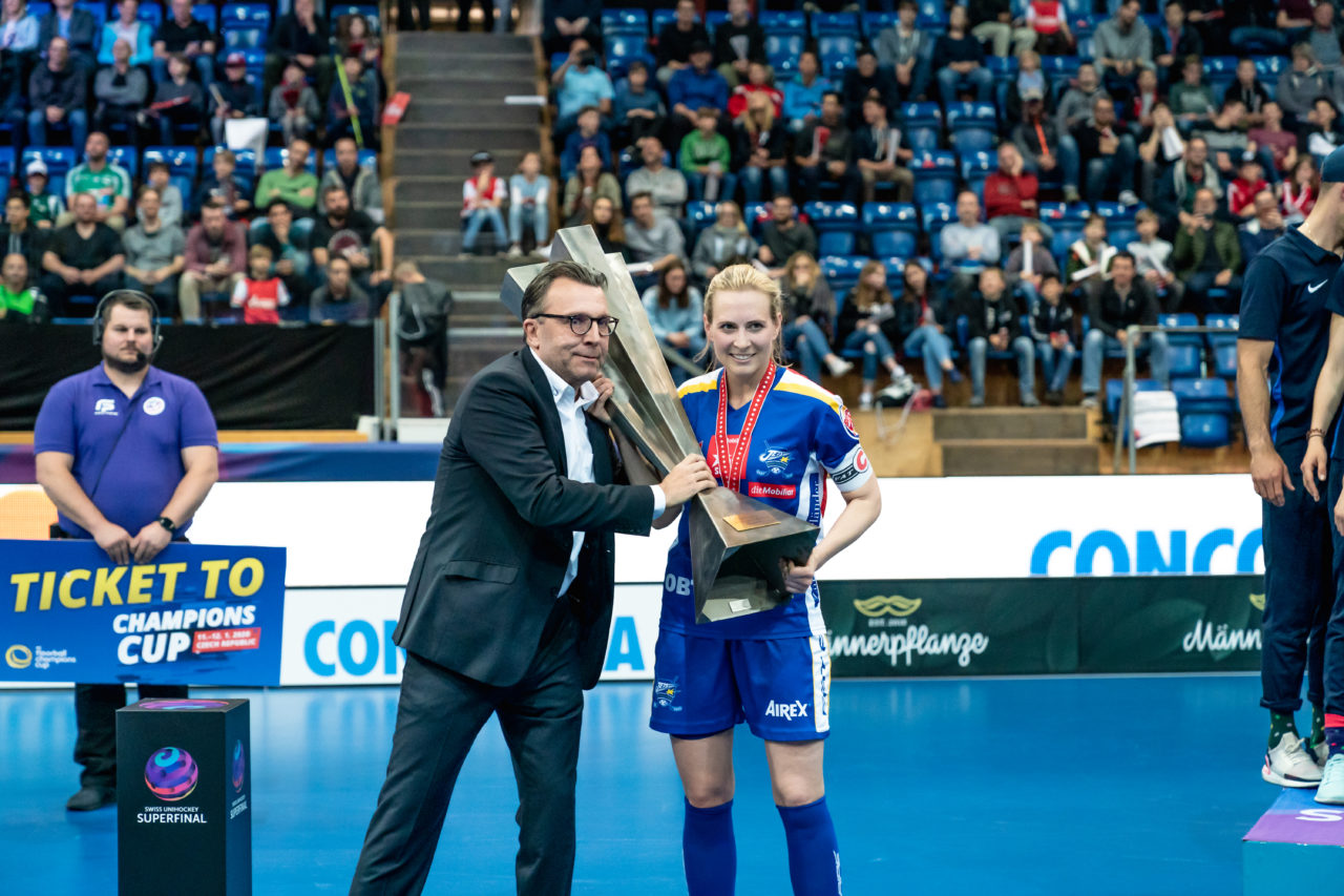 SWISS Arena (Kloten), 27.04.2019, Unihockey Damen NLA Superfinal, piranha chur - Kloten-Dietlikon Jets, Daniel Bareiss übergibt Michelle Wiki (Nr. 6, Kloten-Dietlikon Jets) den Pokal
(Claudio Schwarz, unihockey-fotos.ch)
Copyright: Claudio Schwarz, unihockey-fotos.ch – Dieses Bild wurde durch swiss unihockey lizenziert und darf ausschliesslich auf den Online-Kanälen von swiss unihockey verwendet werden. Die redaktionelle oder kommerzielle Nutzung durch Dritte (Medien, Vereine, Unternehmen oder Privatpersonen) per Download von diesem flickr-Account ist ausgeschlossen. Das Bild kann bei Interesse via unihockey-fotos.ch kostenpflichtig lizenziert werden. unihockey-fotos.ch behält sich vor, fehlbaren Medien, Vereinen, Unternehmen oder Privatpersonen Bilder mit einem Zuschlag in Rechnung zu stellen.