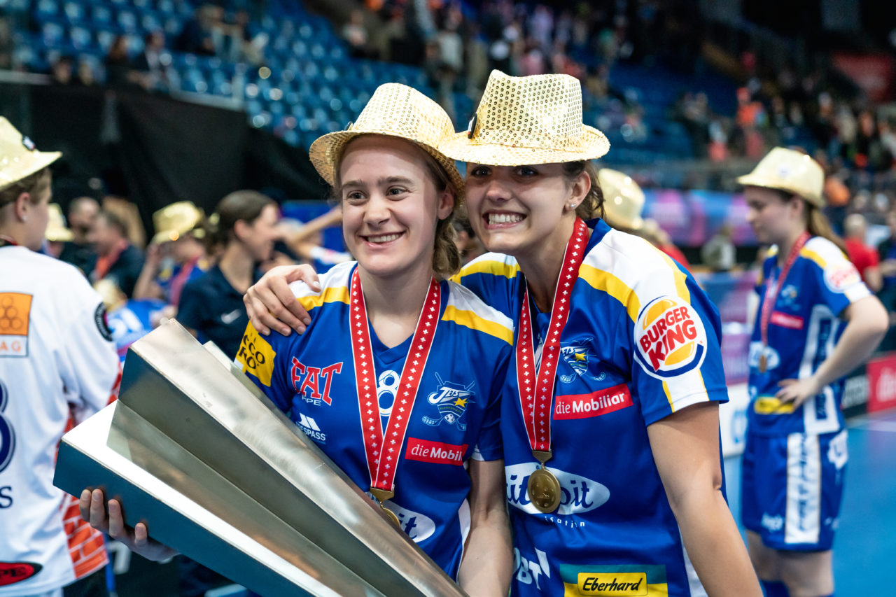 SWISS Arena (Kloten), 27.04.2019, Unihockey Damen NLA Superfinal, piranha chur - Kloten-Dietlikon Jets, Kassandra Luck (Nr. 18, Kloten-Dietlikon Jets) und Linda Pedrazzoli (Nr. 13, Kloten-Dietlikon Jets) mit dem Pokal
(Claudio Schwarz, unihockey-fotos.ch)
Copyright: Claudio Schwarz, unihockey-fotos.ch – Dieses Bild wurde durch swiss unihockey lizenziert und darf ausschliesslich auf den Online-Kanälen von swiss unihockey verwendet werden. Die redaktionelle oder kommerzielle Nutzung durch Dritte (Medien, Vereine, Unternehmen oder Privatpersonen) per Download von diesem flickr-Account ist ausgeschlossen. Das Bild kann bei Interesse via unihockey-fotos.ch kostenpflichtig lizenziert werden. unihockey-fotos.ch behält sich vor, fehlbaren Medien, Vereinen, Unternehmen oder Privatpersonen Bilder mit einem Zuschlag in Rechnung zu stellen.