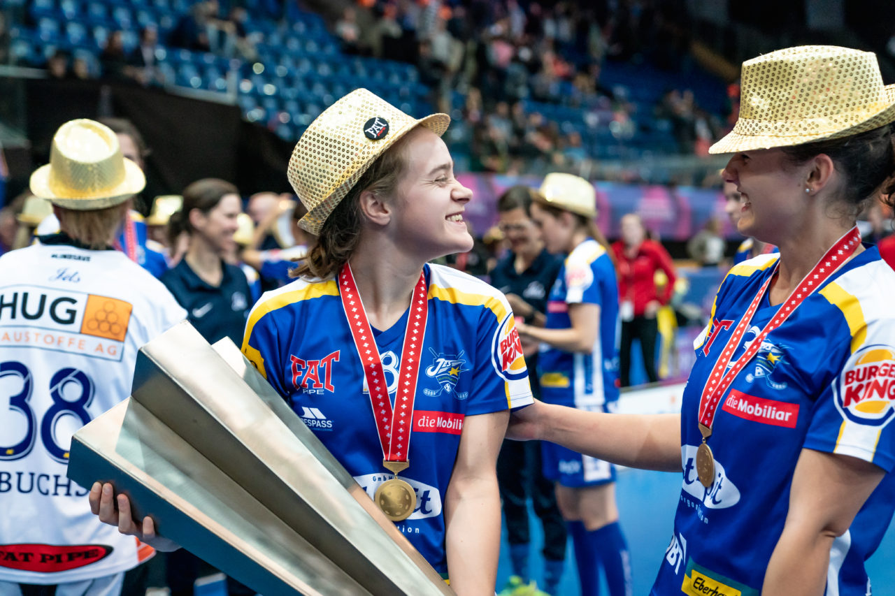 SWISS Arena (Kloten), 27.04.2019, Unihockey Damen NLA Superfinal, piranha chur - Kloten-Dietlikon Jets, Kassandra Luck (Nr. 18, Kloten-Dietlikon Jets) und Linda Pedrazzoli (Nr. 13, Kloten-Dietlikon Jets) mit dem Pokal
(Claudio Schwarz, unihockey-fotos.ch)
Copyright: Claudio Schwarz, unihockey-fotos.ch – Dieses Bild wurde durch swiss unihockey lizenziert und darf ausschliesslich auf den Online-Kanälen von swiss unihockey verwendet werden. Die redaktionelle oder kommerzielle Nutzung durch Dritte (Medien, Vereine, Unternehmen oder Privatpersonen) per Download von diesem flickr-Account ist ausgeschlossen. Das Bild kann bei Interesse via unihockey-fotos.ch kostenpflichtig lizenziert werden. unihockey-fotos.ch behält sich vor, fehlbaren Medien, Vereinen, Unternehmen oder Privatpersonen Bilder mit einem Zuschlag in Rechnung zu stellen.