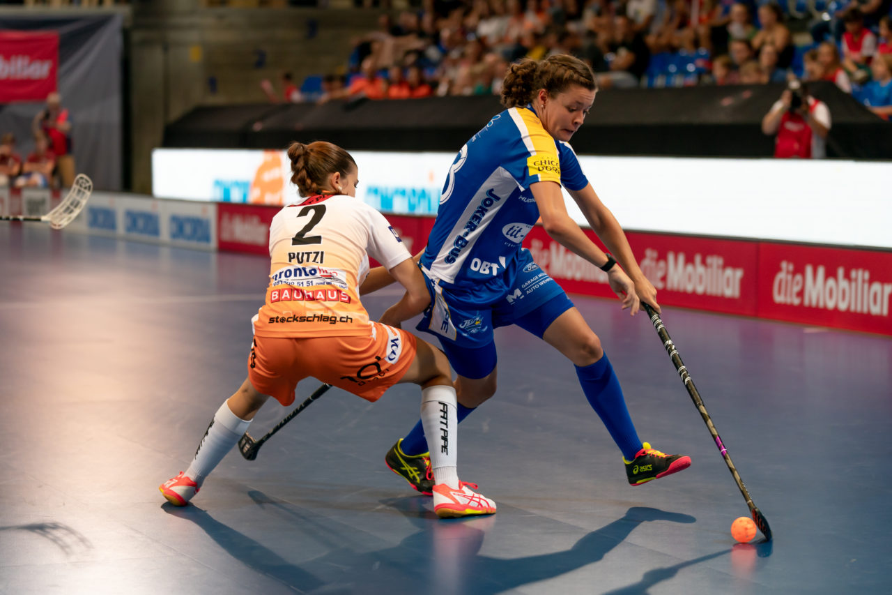Saalsporthalle (Zürich), 31.08.2019, Unihockey Damen Supercup 2019, Kloten-Dietlikon Jets - piranha chur, Isabelle Gerig (Nr. 23, Kloten-Dietlikon Jets) zieht an Jana Putzi (Nr. 2, piranha chur) vorbei

(Claudio Schwarz, unihockey-fotos.ch)