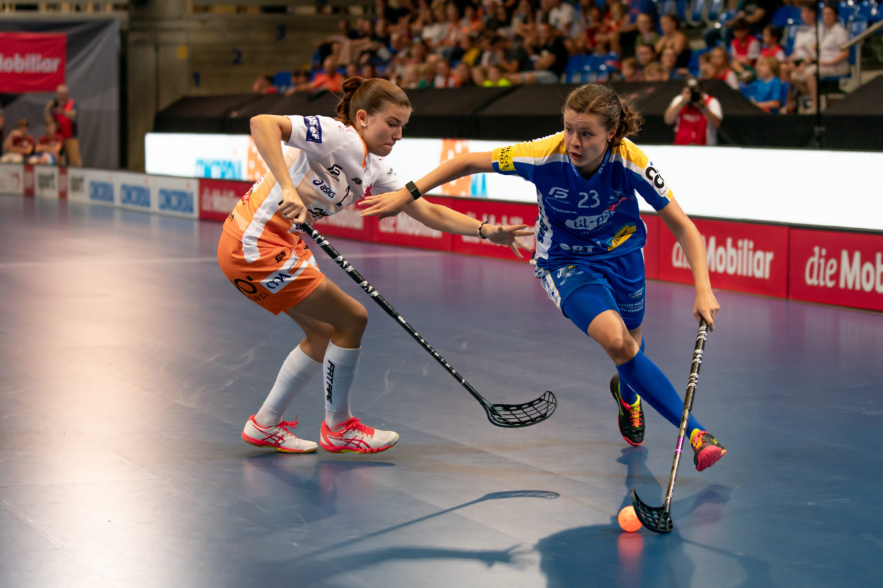 Saalsporthalle (Zürich), 31.08.2019, Unihockey Damen Supercup 2019, Kloten-Dietlikon Jets - piranha chur, Isabelle Gerig (Nr. 23, Kloten-Dietlikon Jets) zieht an Jana Putzi (Nr. 2, piranha chur) vorbei

(Claudio Schwarz, unihockey-fotos.ch)